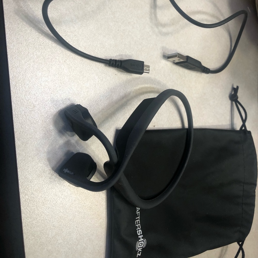 AfterShokz ear phones. Comes with charging cable. Bluetooth compatible.